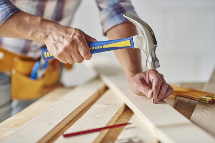 Carpenter with hammer hitting nails