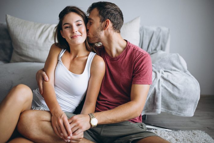 Portrait of couple at home together sitting on floor by the coach