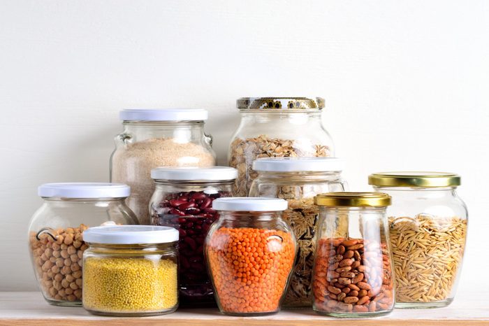 Collection of cereals in storage jars in pantry.