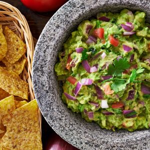 mexican guacamole in molcajete with tortilla chips