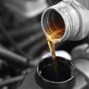 Pouring oil to car engine, close up