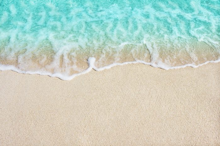 Soft beautiful ocean wave on sandy beach. Background.