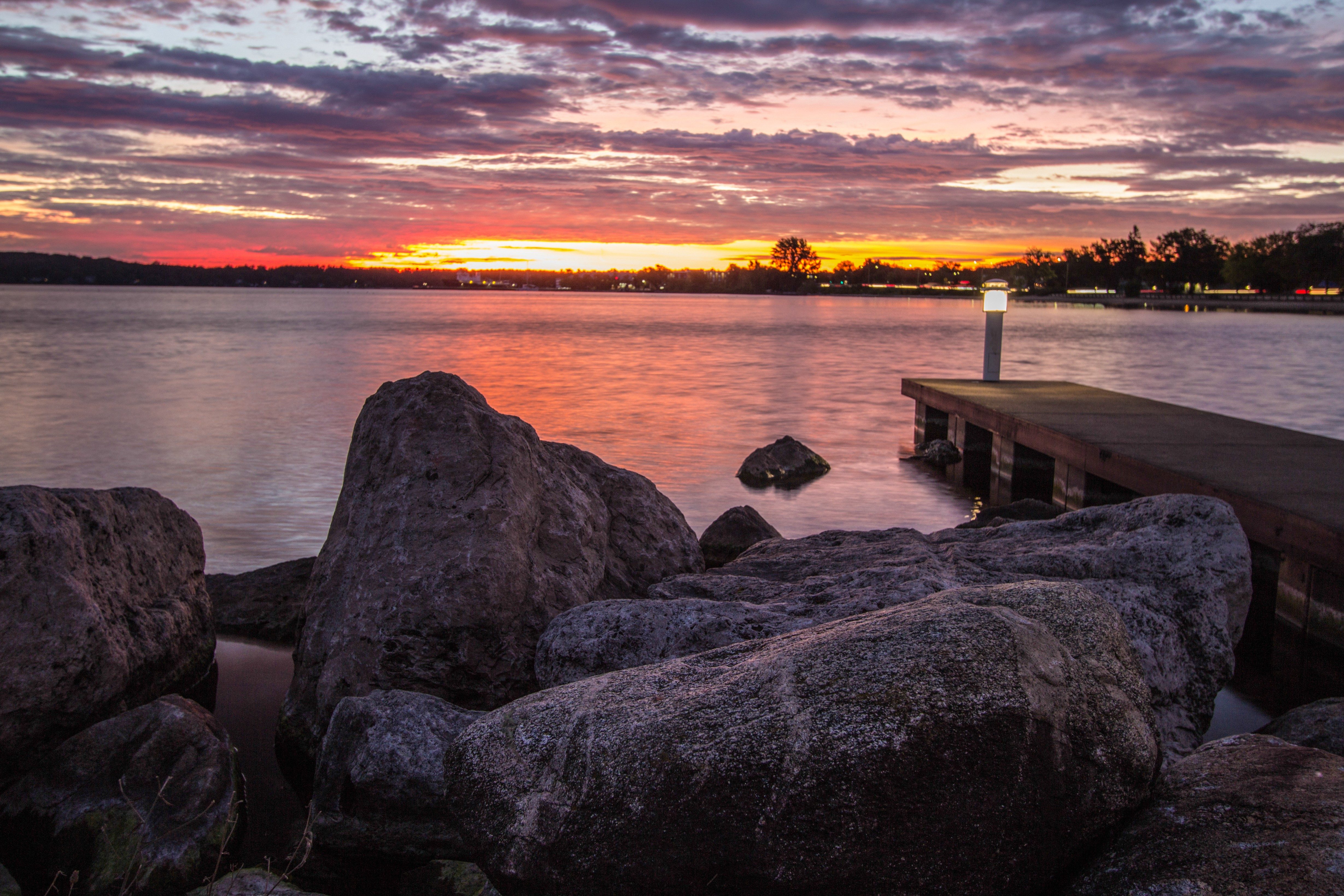 Downtown Traverse City Coastal Sunrise. Morning sunrise over the rocky coast of Grand Traverse Bay with downtown Traverse City, Michigan in the background.