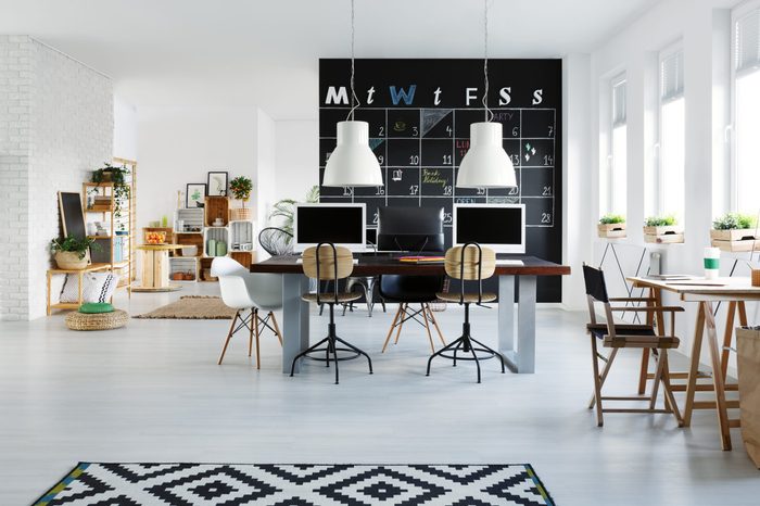 White office interior with desk, computers, chair and pattern rug