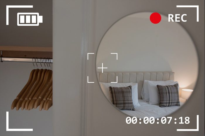 view of bed through mirror in hotel room with camera viewfinder overlay