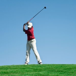 lone golfer stands on the horizon line