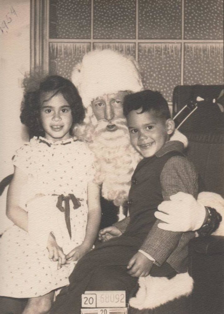 Childhood Christmas experiences are incomplete without a visit to the department store Santa Claus! Here my siblings; Olga and Ruben Garcia; 7 and 5; are all smiles while perched on Santa's lap. The photo was taken in San Francisco; California; in 1954. I was actually already two years old at the time; but was so terrified of Santa that my one and only picture with him was taken when I was eight. After that; I felt I was too old to sit on his lap.