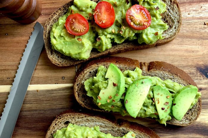 Top view of avocado toast on a wood cutting board