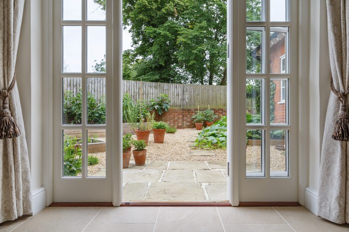 View of garden from inside house with french doors leading to a courtyard kitchen garden