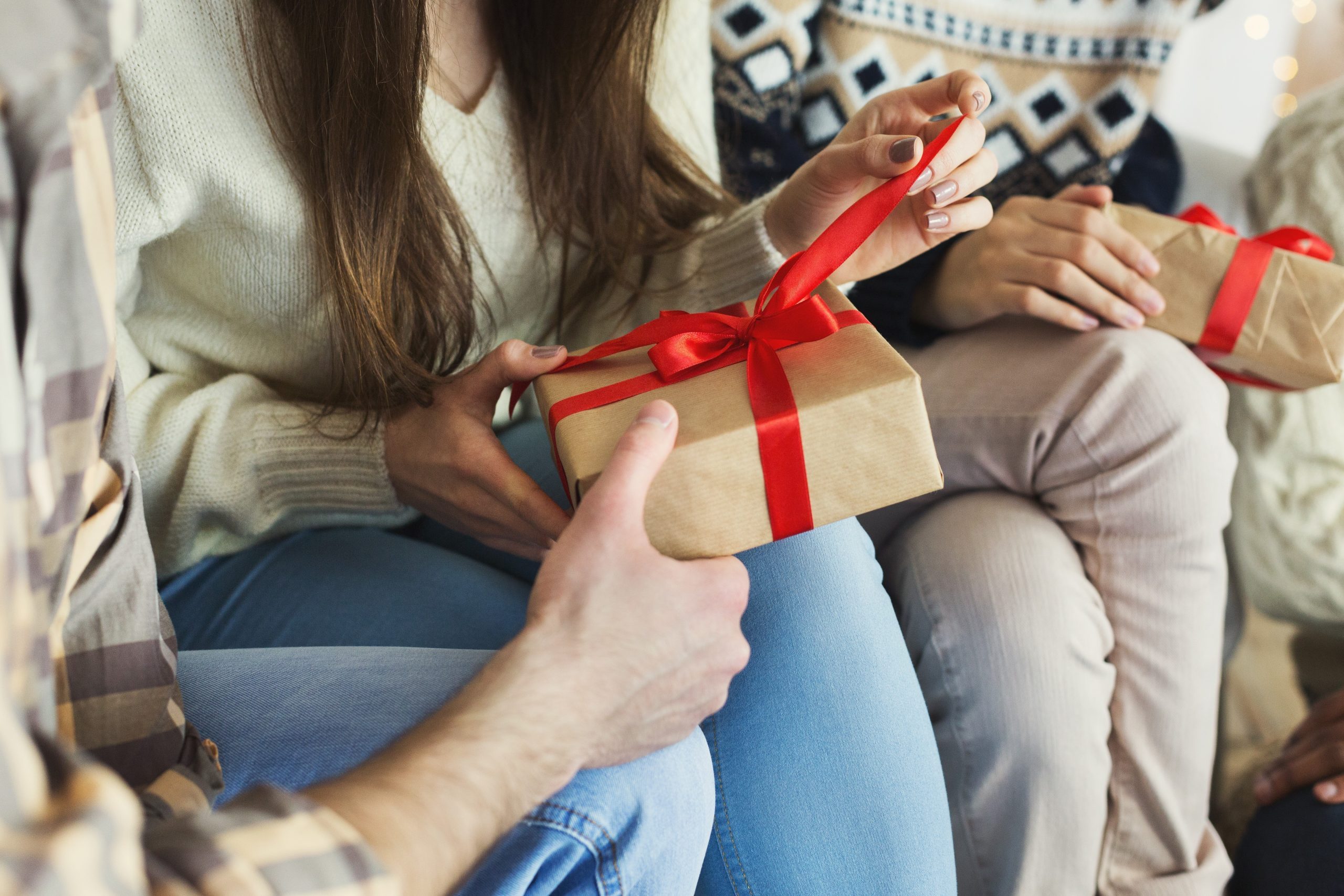 Presenting gifts as Christmas eve tradition. Group of friends exchanging xmas presents at home, closeup, copy space