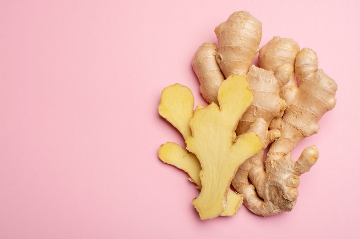 Trendy food flat lay concept on light pink background with fresh big ginger root close up copy space isolated