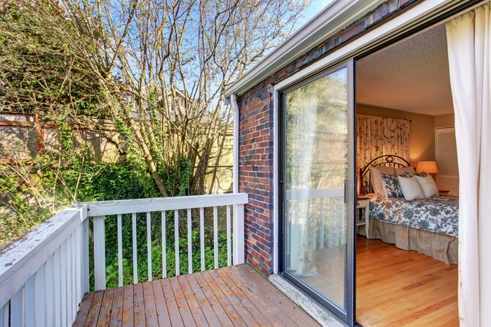 Timeless bedroom with floral bedding, and a sliding glass door.