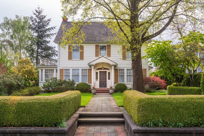 Beautiful exterior of newly built luxury home. Yard with green grass and walkway lead to front entrance.