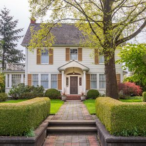 Beautiful exterior of newly built luxury home. Yard with green grass and walkway lead to front entrance.