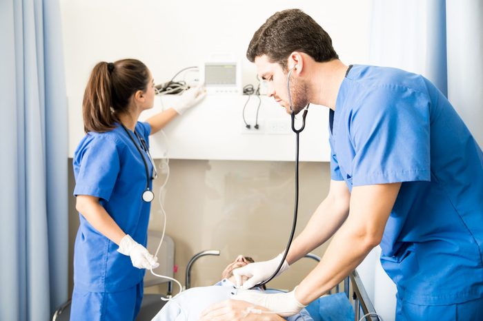 Team of medics checking heart beats of a patient in emergency room