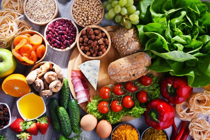 Composition with assorted organic food products on wooden kitchen table.