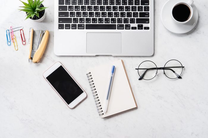 Stylized marble office working desk with smartphone, laptop, glasses and coffee, workspace design, mock up, top view, flat lay, copyspace, closeup