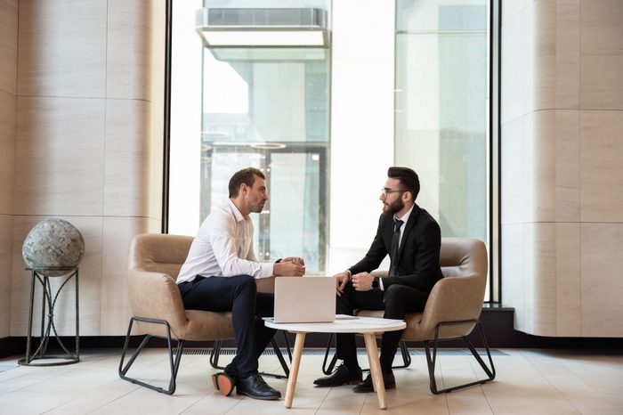 Businessmen discussing deal, sharing startup ideas, business partners negotiations or job interview in modern office with panoramic windows, colleagues talking, working on project together