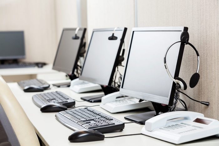 Row of computers with headphones on desk at call center