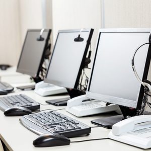 Row of computers with headphones on desk at call center