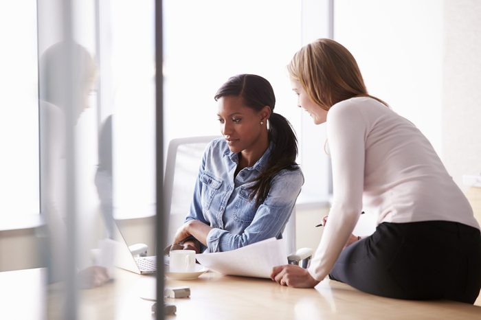 Two Casually Dressed Businesswomen Working In Office