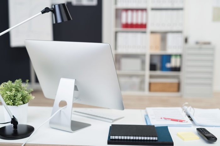 Manager Table with Desktop Computer and Business Notes Inside the Office.