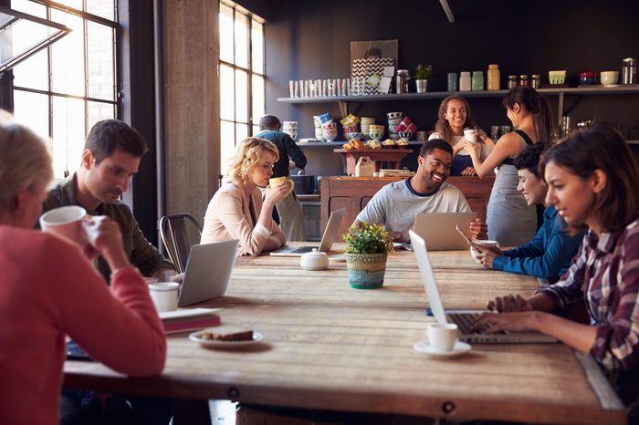 Interior Of Coffee Shop With Customers Using Digital Devices