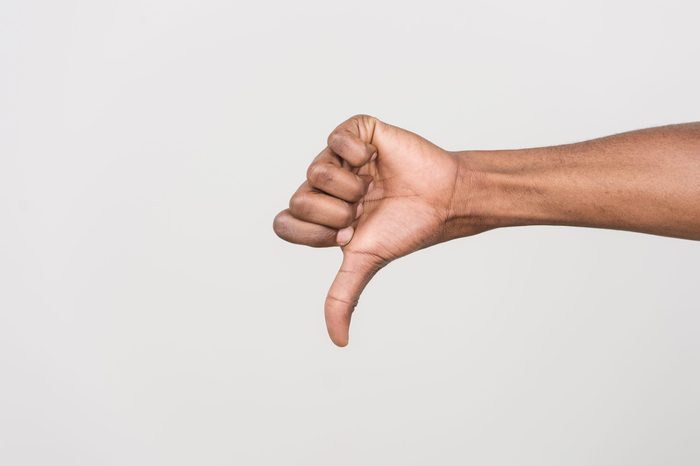 Thumb down hand signs isolated on white. black man hand gesturing with hand on white