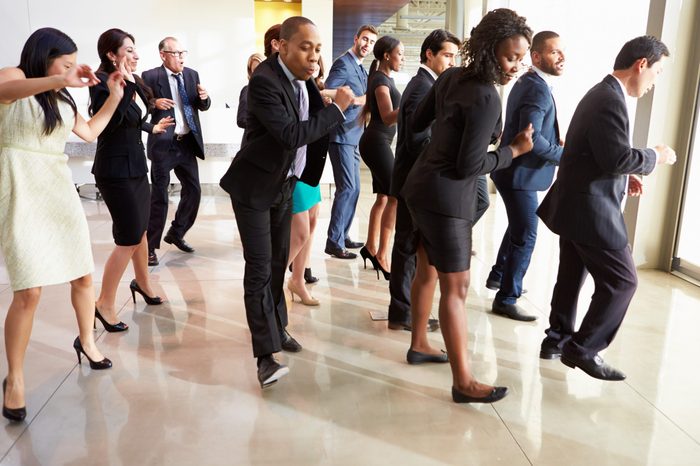 Businessmen And Businesswomen Dancing In Office Lobby