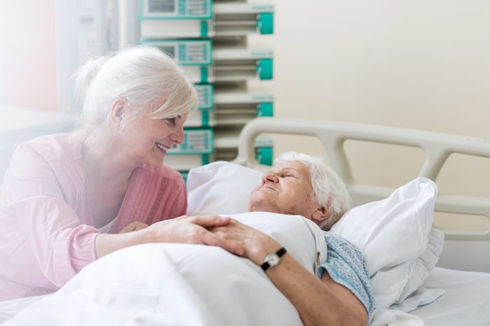 Daughter visiting her senior mother in hospital