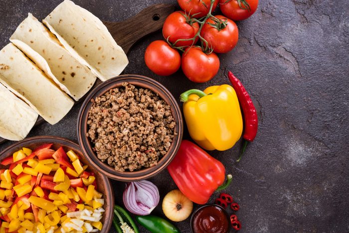 Mexican tacos with vegetables and meat. Ingredient for cooking tacos al pastor on concrete background. Top view