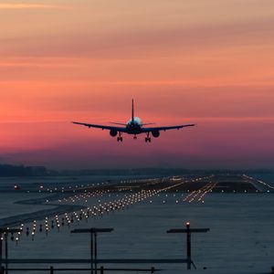 passenger plane is landing in the airport runway at early morning at sunrise time in the frosty winter air