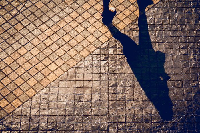 Shadow of a person walking in a street in the city