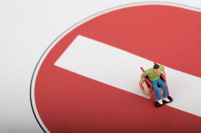 miniature of a disabled man in a wheelchair on a no entry sign