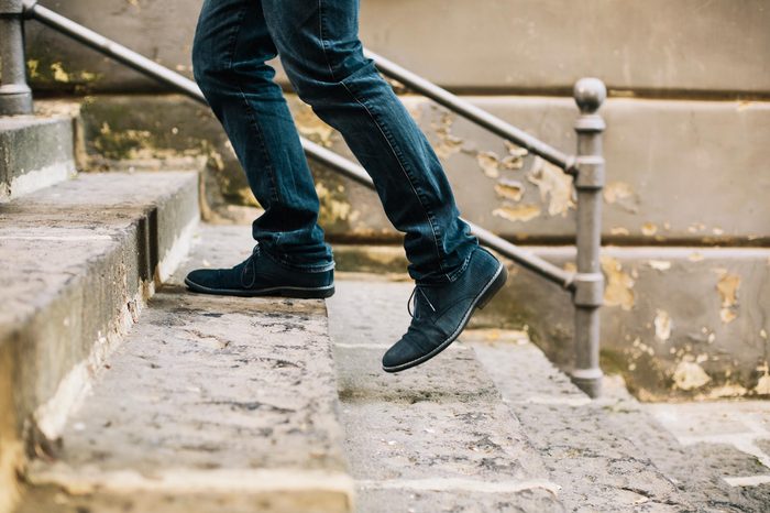 Close-up of man's shoes walking upstairs