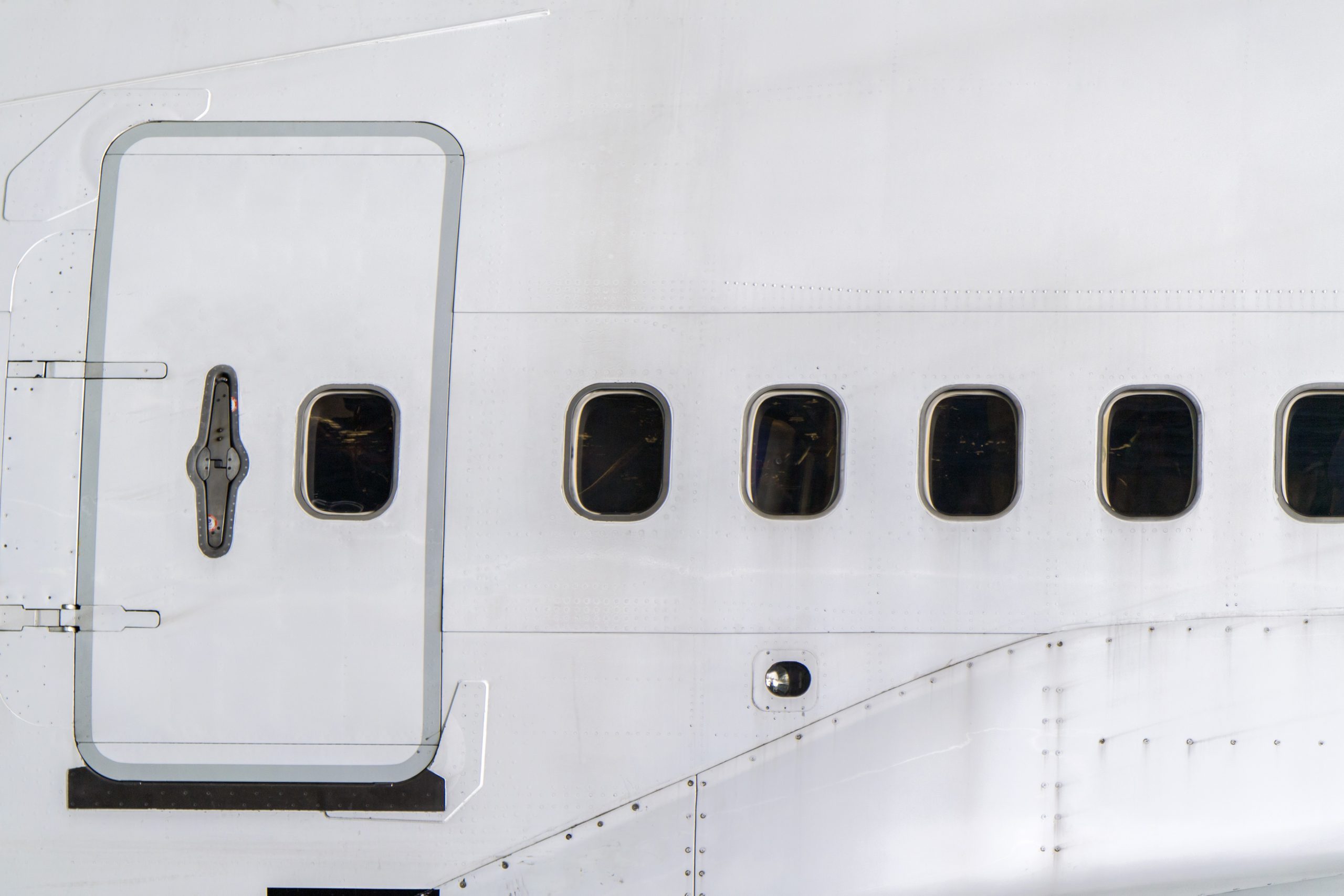 Windows of airplane with emergency exit door.
