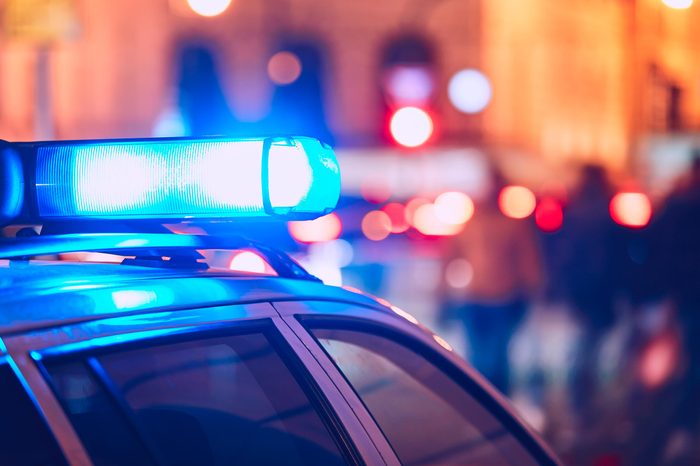 close up on blue police car light with blurred city lights in the background