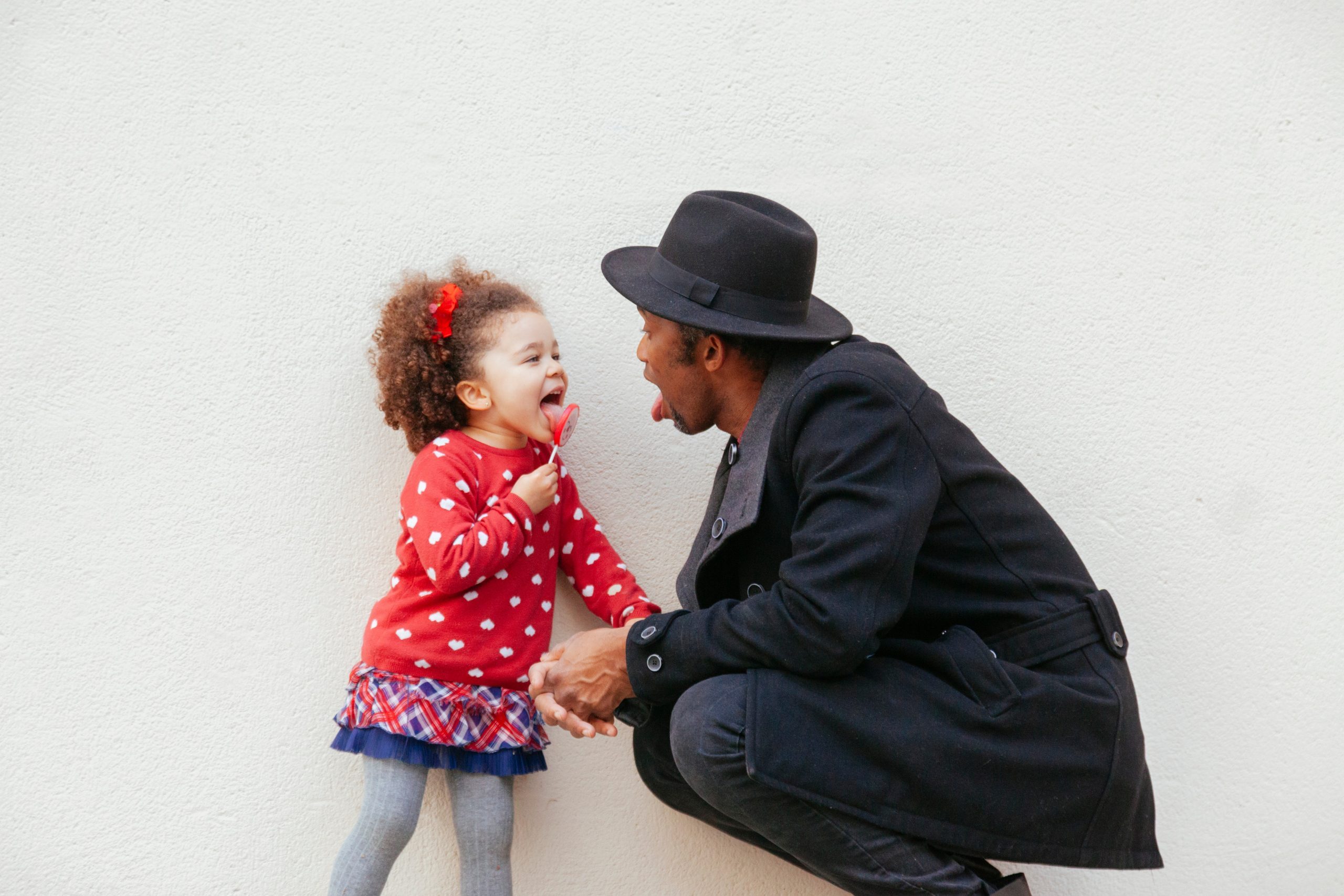 little girl licking a big candy with daddy