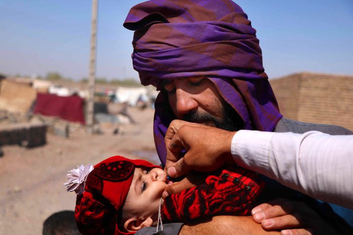 A health worker administers a Polio vaccination to a child at a camp setup by the World Vision NGO and UNICEF in Herat, Afghanistan, 08 August 2018.