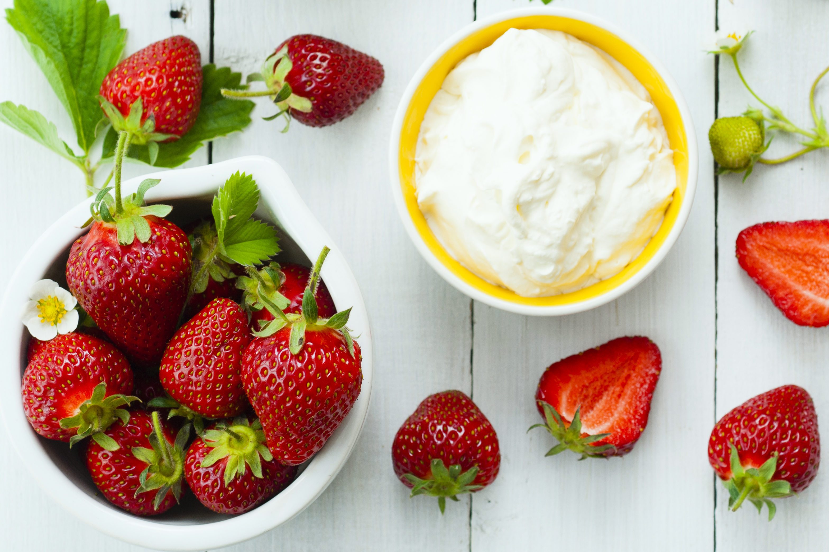 strawberry fruits and whipped cream dessert on white wood table background