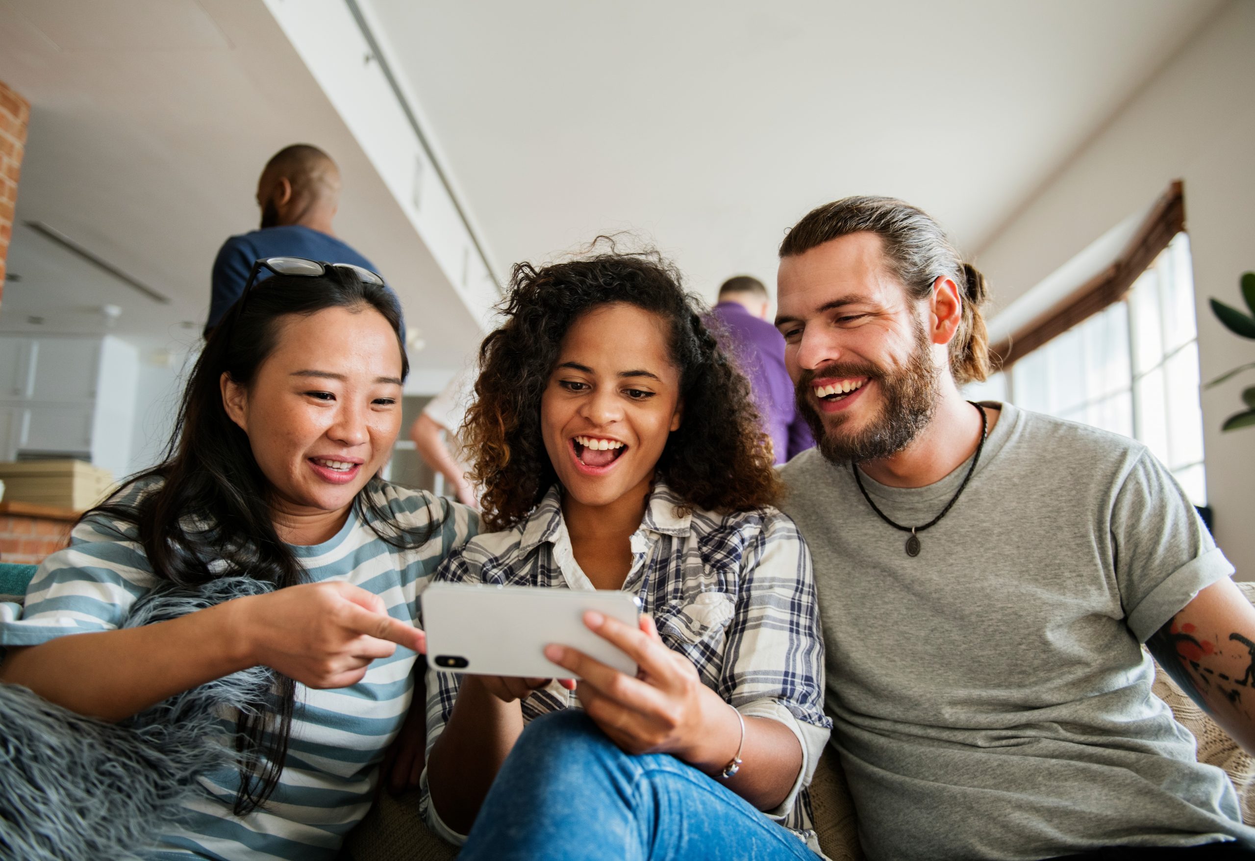 Group of diverse friends playing game on mobile phone