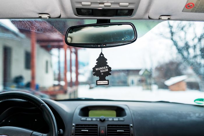 Hanging Black Classic Wunder Baum air freshener on car interior.