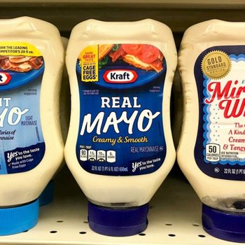 Several bottles of kraft mayonnaise on shelve at a grocery store