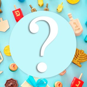 religion image of jewish holiday Hanukkah with menorah (traditional candelabra), spinning top over wooden blue background. top view, flat lay with question mark in the center