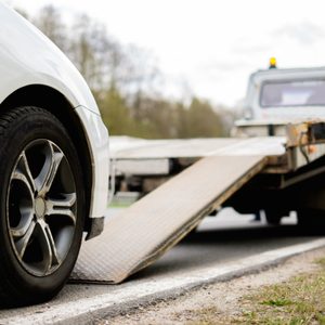 Loading broken car on a tow truck on a roadside 