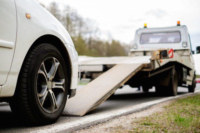 Loading broken car on a tow truck on a roadside 