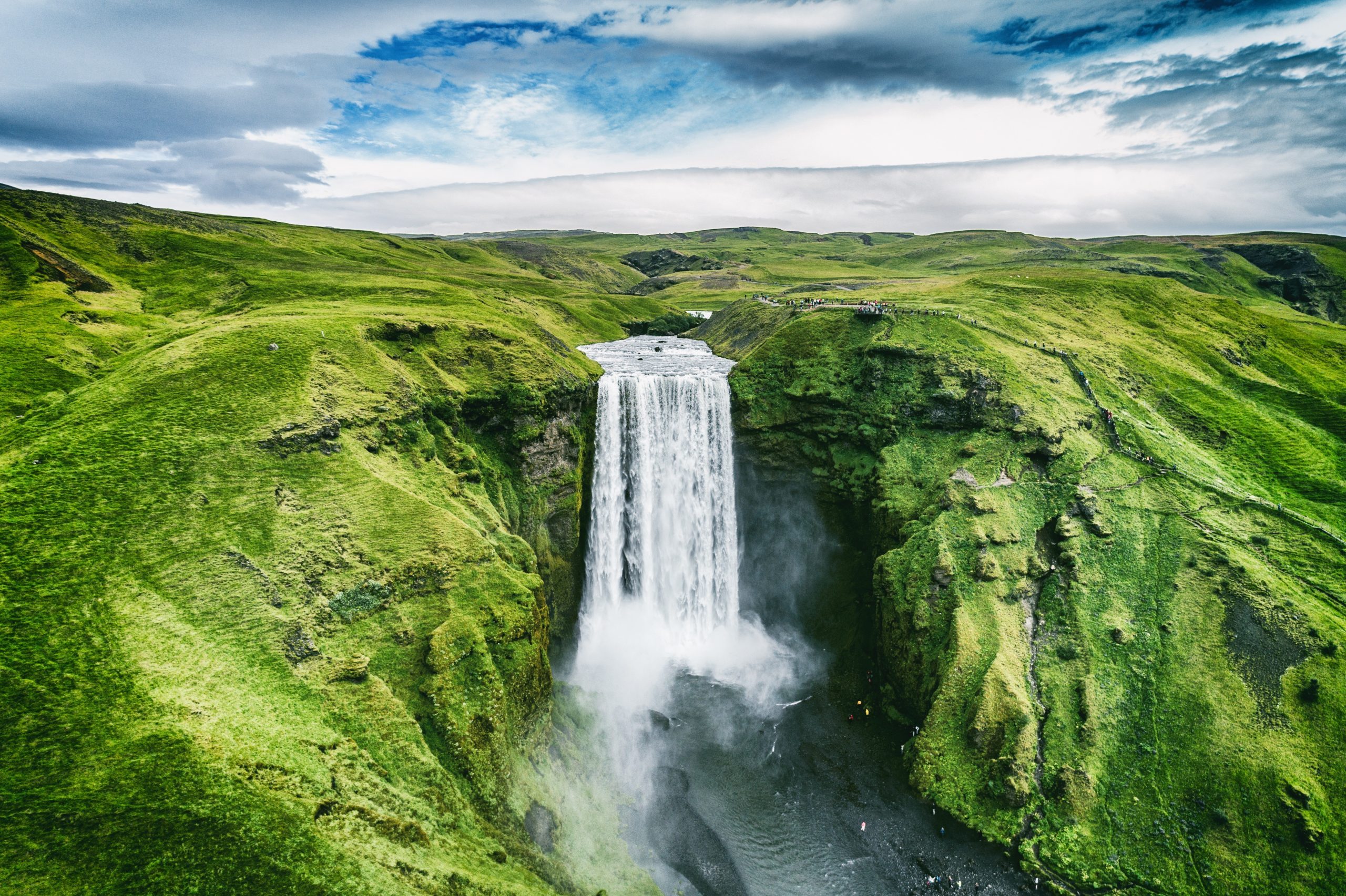 Iceland waterfall Skogafoss in Icelandic nature landscape. Famous tourist attractions and landmarks destination in Icelandic nature landscape on South Iceland. Aerial drone view of top waterfall.