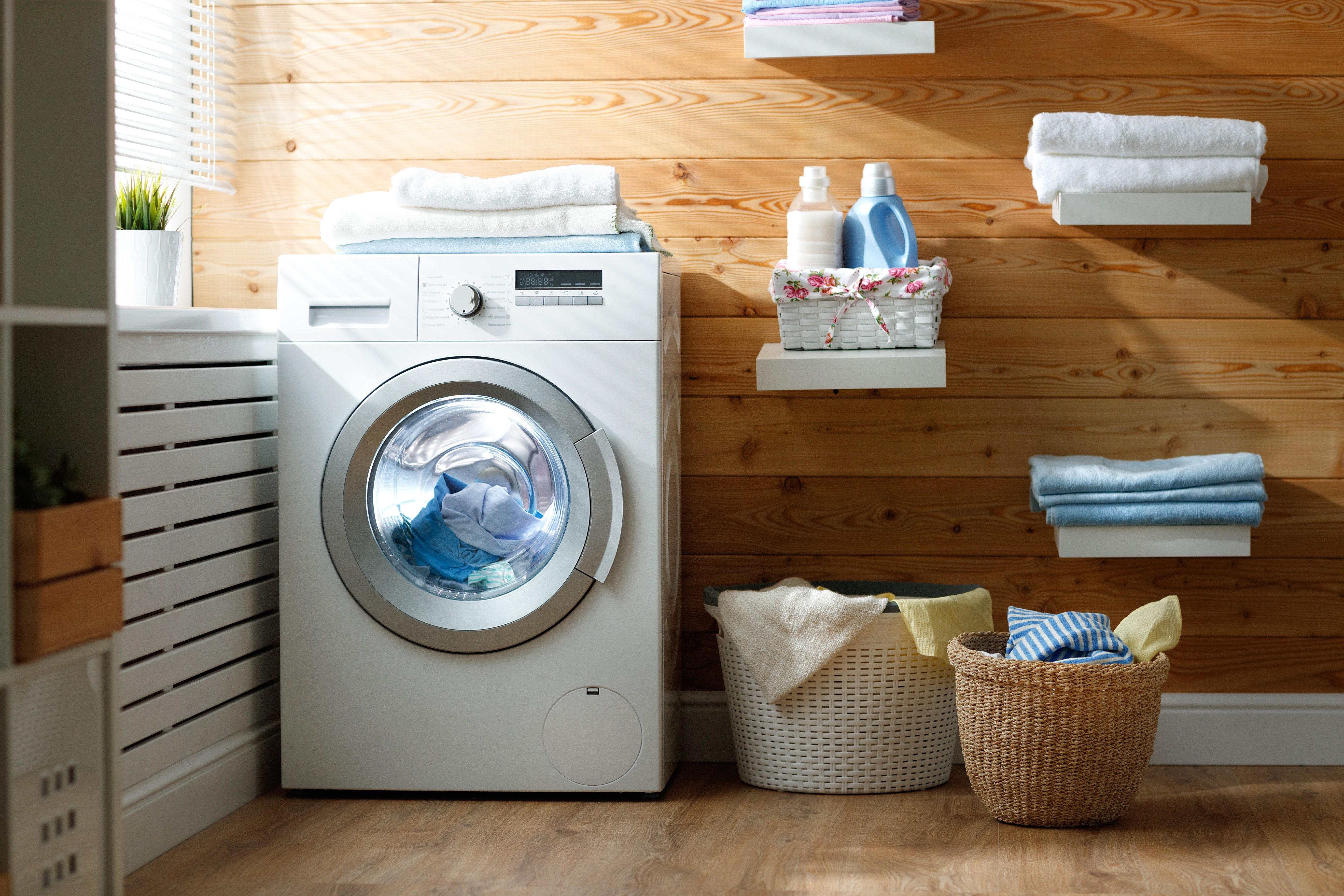 Interior of a real laundry room with a washing machine at the window at home