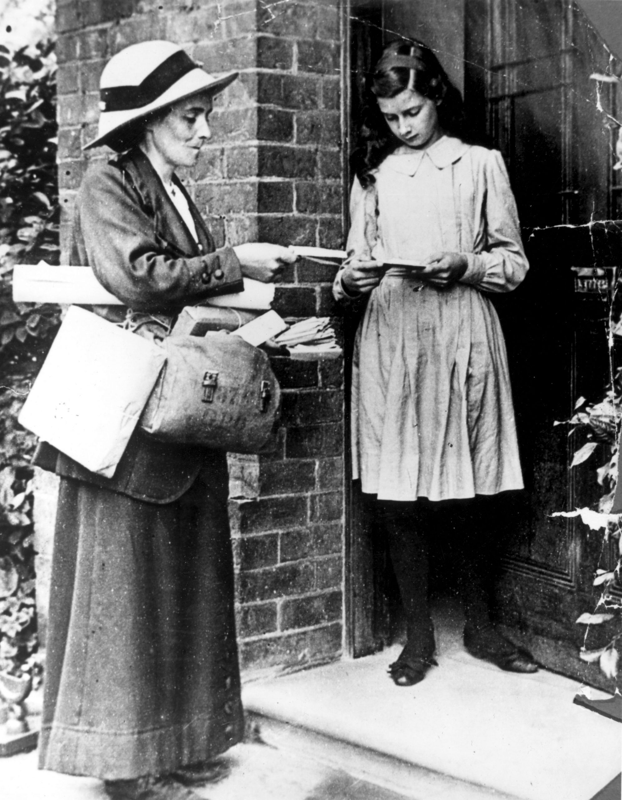 circa 1917: A post woman delivering post.