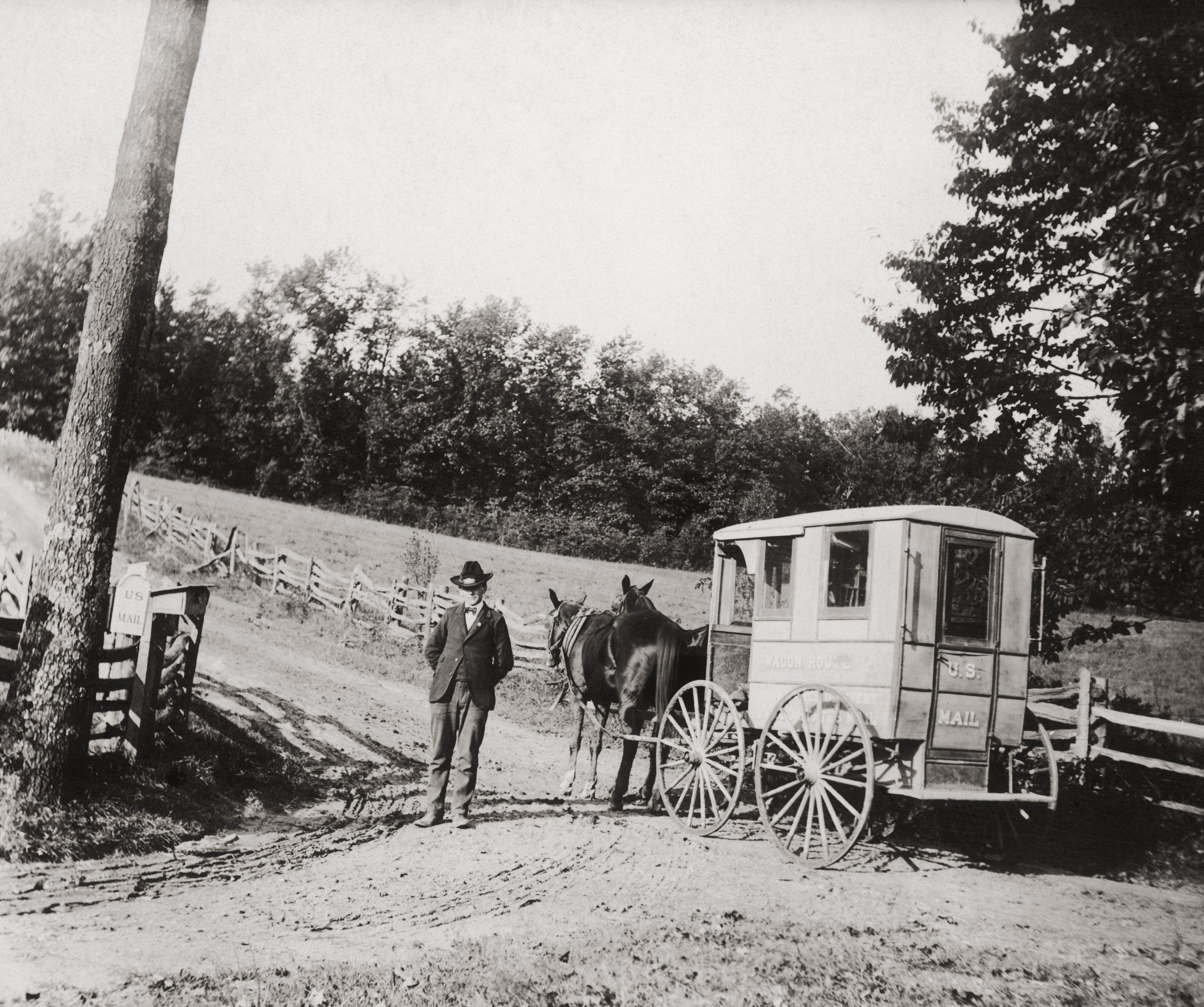 A postman resting his horses before going up a steep hill, USA, circa 1920